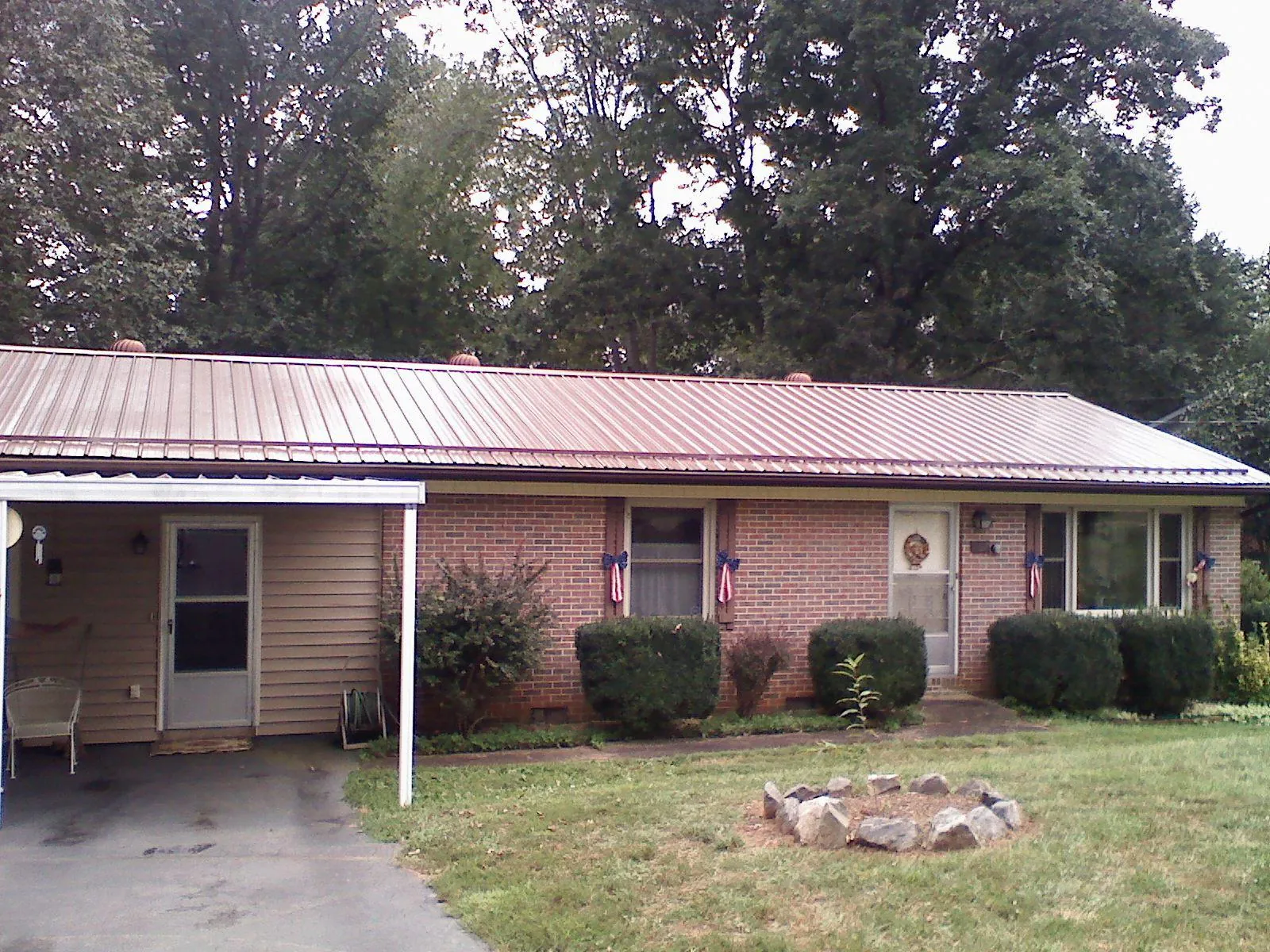 Bronze metal roof and carport on a brick ranch home — Roof Repair work by our crew in Cayuta